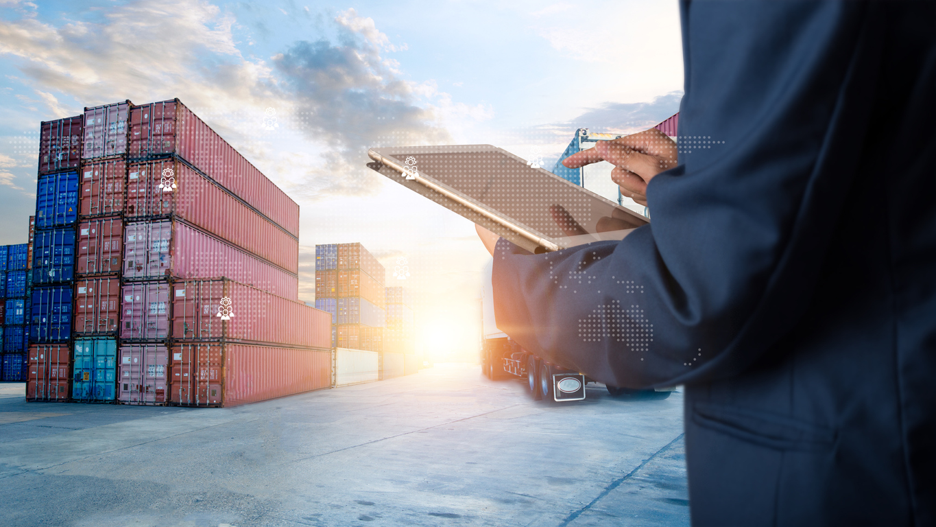 Person with a tablet checks cargo containers